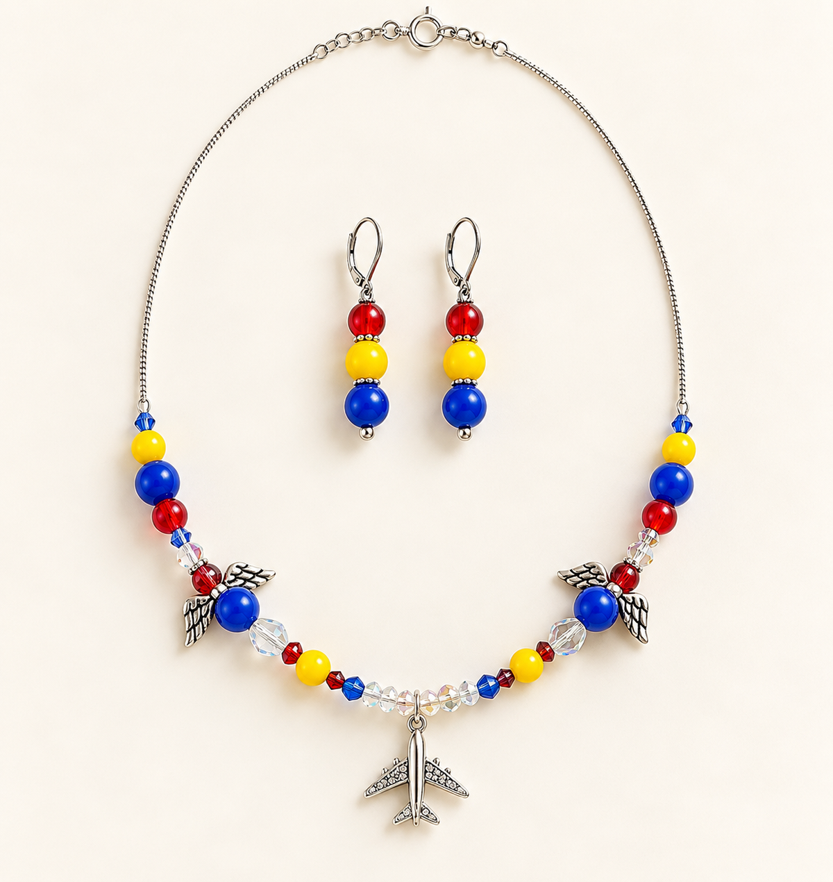 Silver-tone snake chain necklace with colorful beads, two angel-wing charms, and an airplane pendant, with matching silver-tone drop earrings